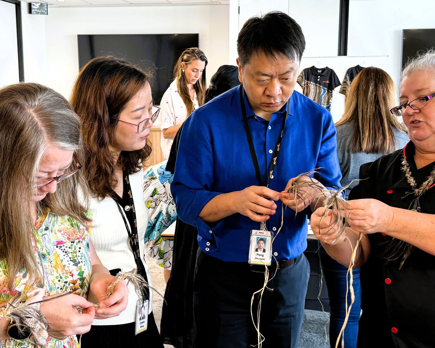 Group of people learning about indigenous weaving from Valerie Murray in a workshop setting.